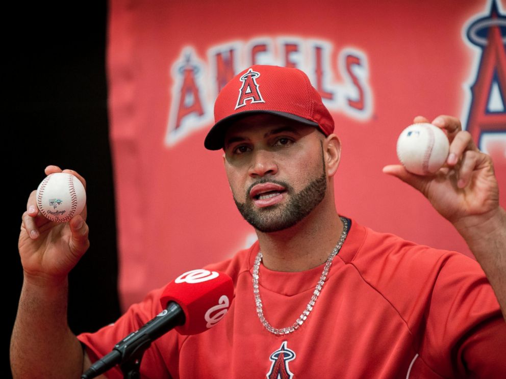 PHOTO: Los Angeles Angels Albert Pujols holds up the balls that he hit for his 499th, right, and 500th, left, career homers, April 22, 2014.