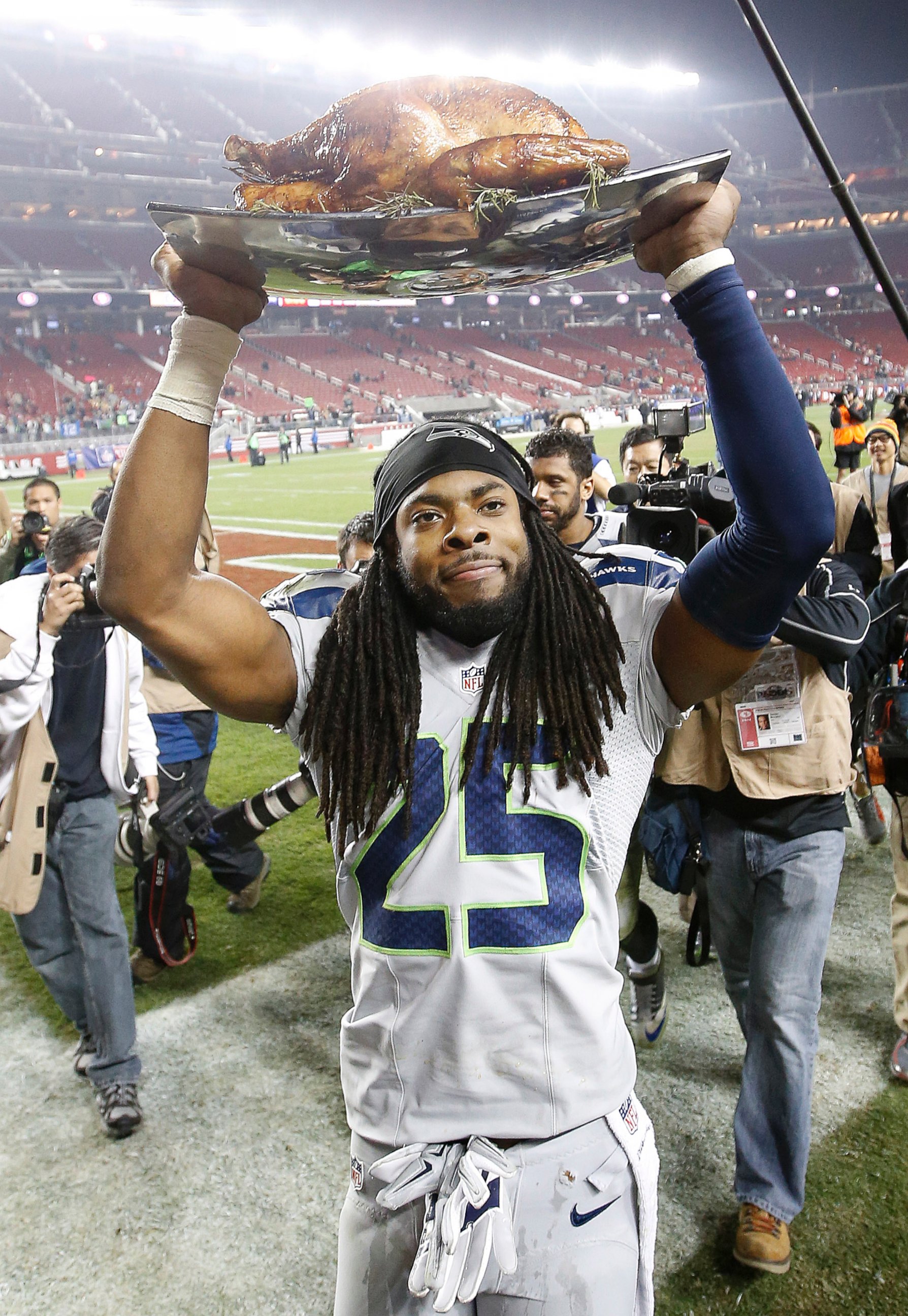 PHOTO: Seattle Seahawks cornerback Richard Sherman carries a turkey off the field after the Seahawks beat the San Francisco 49ers, Nov. 27, 2014.
