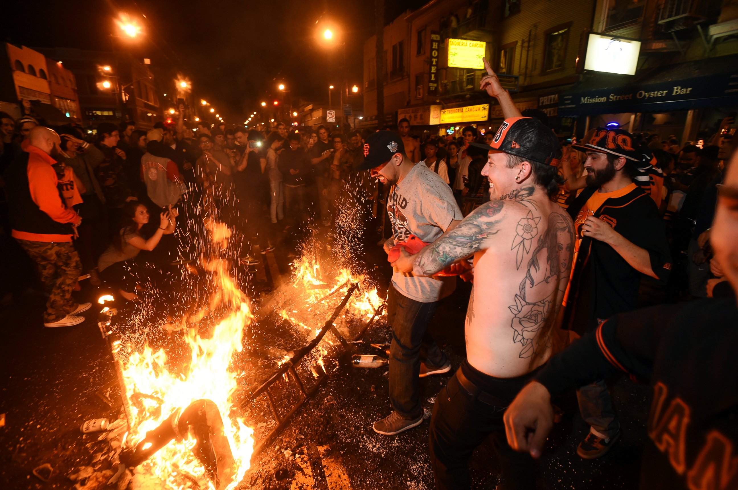 San Francisco Giants fans celebrate next to debris that has been set on fire in the Mission district after the San Francisco Giants beat the Kansas City Royals to win the World Series on Wednesday, Oct. 29, 2014, in San Francisco.