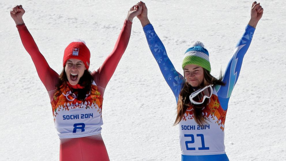 Women's downhill gold medal winners Switzerland's Dominique Gisin, left, and Slovenia's Tina Maze stand together on the podium during a flower ceremony at the Sochi 2014 Winter Olympics, Wednesday, Feb. 12, 2014, in Krasnaya Polyana, Russia.