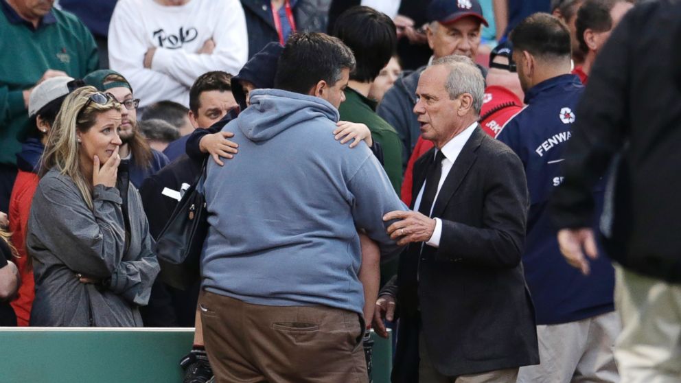 PHOTO: Boston Red Sox president and CEO Larry Lucchino comforts a man holding a child after a woman they were sitting with was hit by a wooden shard, off a broken bat of Oakland Athletics' Brett Lawrie, at Fenway Park in Boston, Friday, June 5, 2015.
