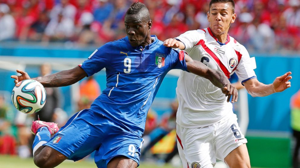 PHOTO: Italy's Mario Balotelli, left, gets in a shot despite the challenge of Costa Rica's Oscar Duarte during the group D World Cup soccer match between Italy and Costa Rica at the Arena Pernambuco in Recife, Brazil, June 20, 2014.