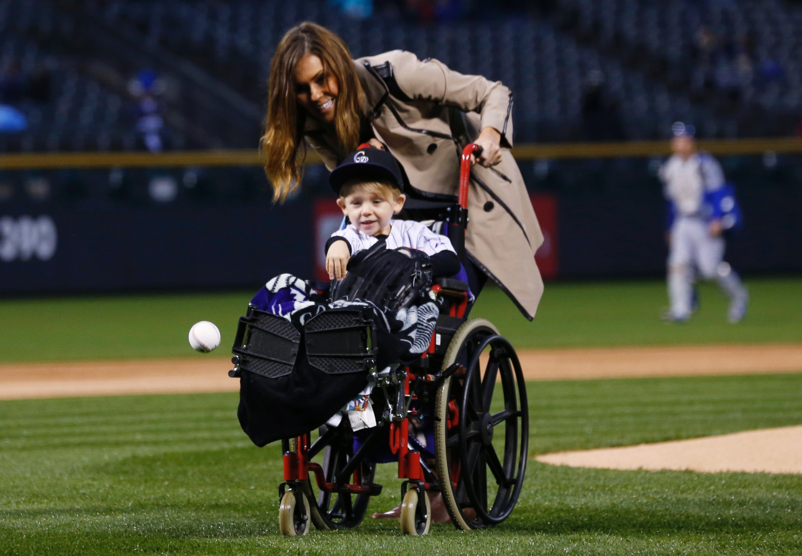 PHOTO: Two-year-old Jameson Axford throws out the ceremonial first pitch as his mother, Nicole, looks on before the Colorado Rockies host the Los Angeles Dodgers in a baseball game Friday, May 8, 2015, in Denver.
