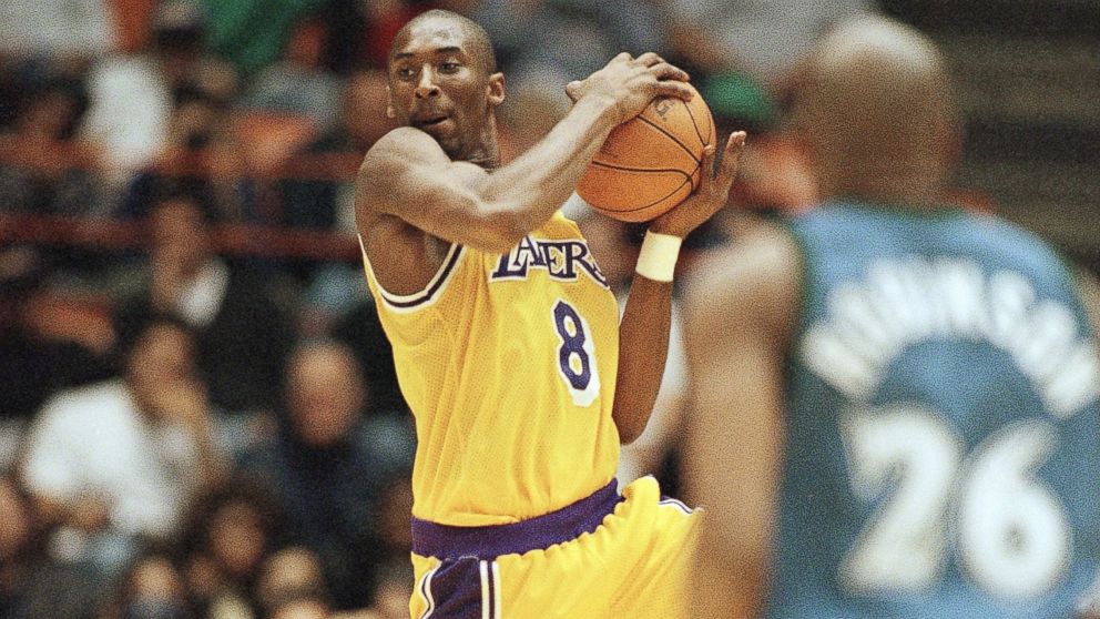 PHOTO: Los Angeles Lakers Kobe Bryant looks for a teammate to pass to as Minnesota Timberwolves James Robinson looks on during Bryant's first game at the Forum in Inglewood, California, Nov. 3, 1996. 