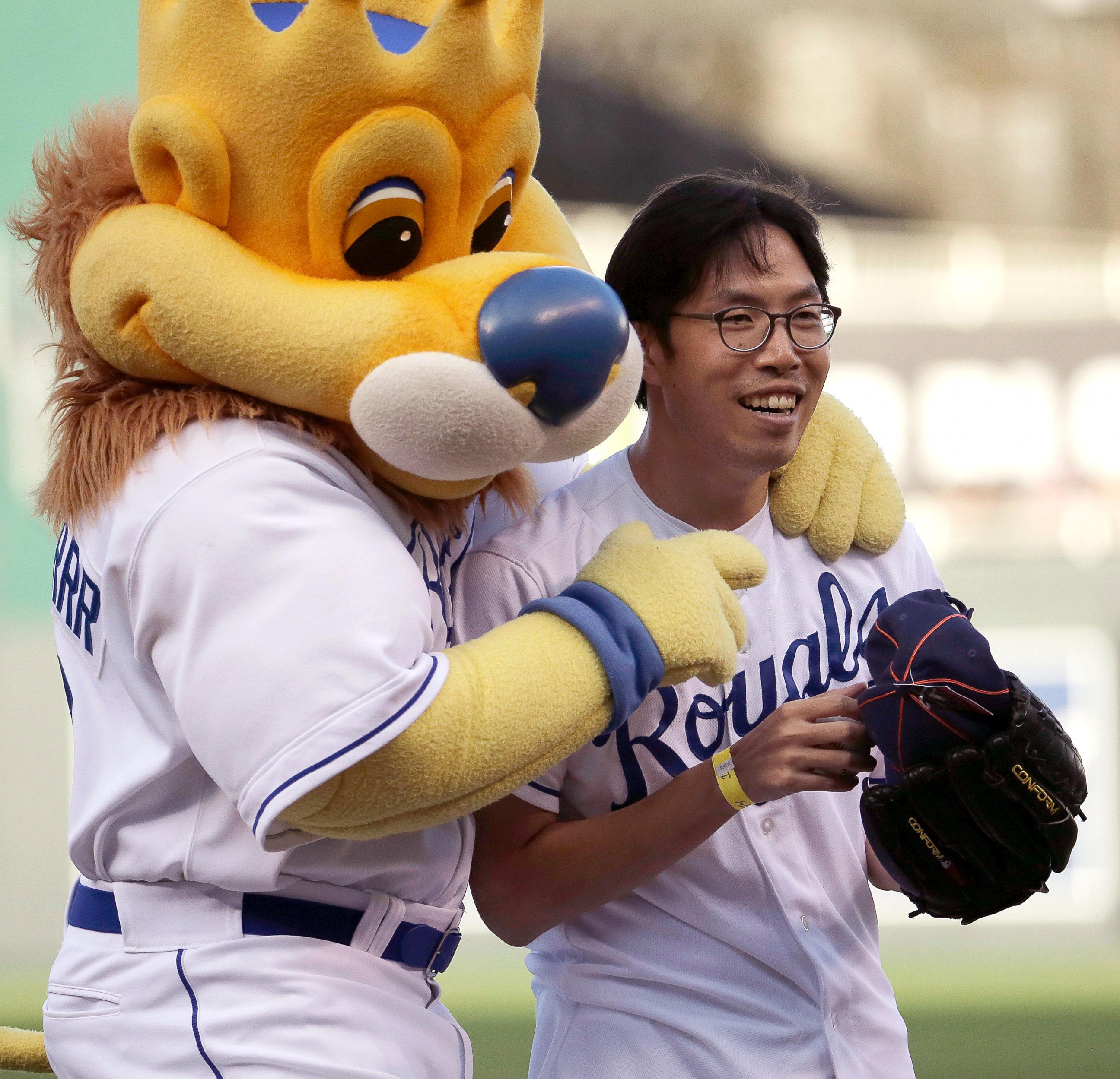 PHOTO: Longtime Kansas City Royals fan Sung Woo Lee, from South Korea, celebrates with Royals mascot Sluggerrr after throwing out the ceremonial first pitch before a baseball game against the Oakland Athletics, Aug. 11, 2014, in Kansas City, Mo.