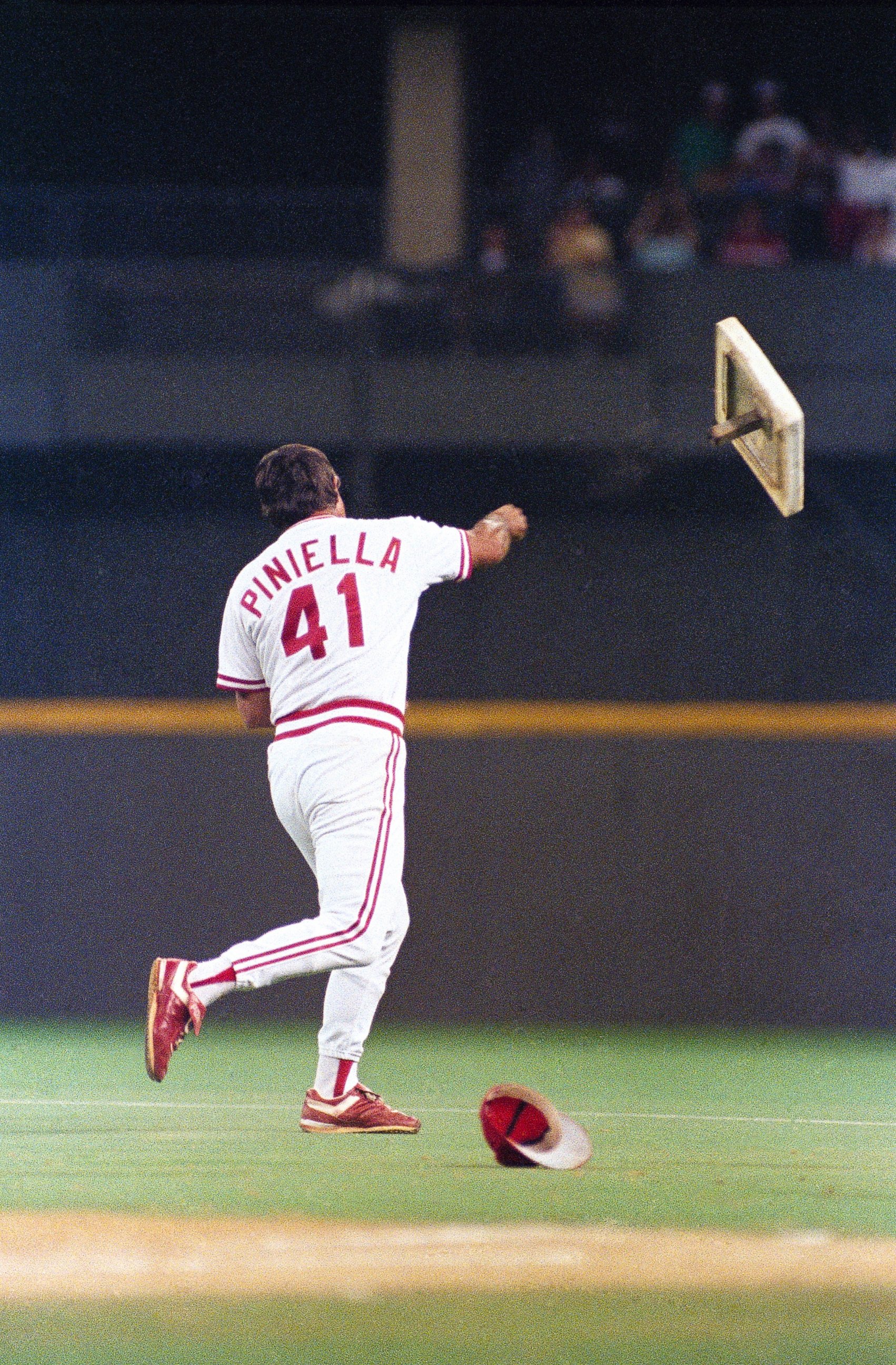 PHOTO: Cincinnati Reds manager Lou Piniella tosses first base into rightfield during their game with the Chicago Cubs at Riverfront Stadium in Cincinnati on April 21, 1990.