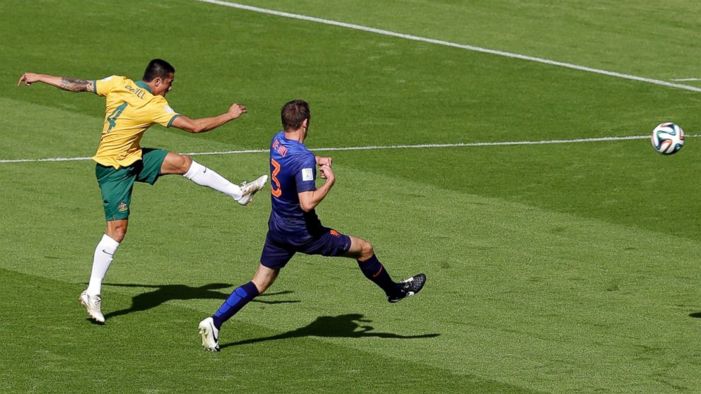 Australia's Tim Cahill, left, scores his side's first goal during the group B World Cup soccer match between Australia and the Netherlands at the Estadio Beira-Rio in Porto Alegre, Brazil, June 18, 2014.