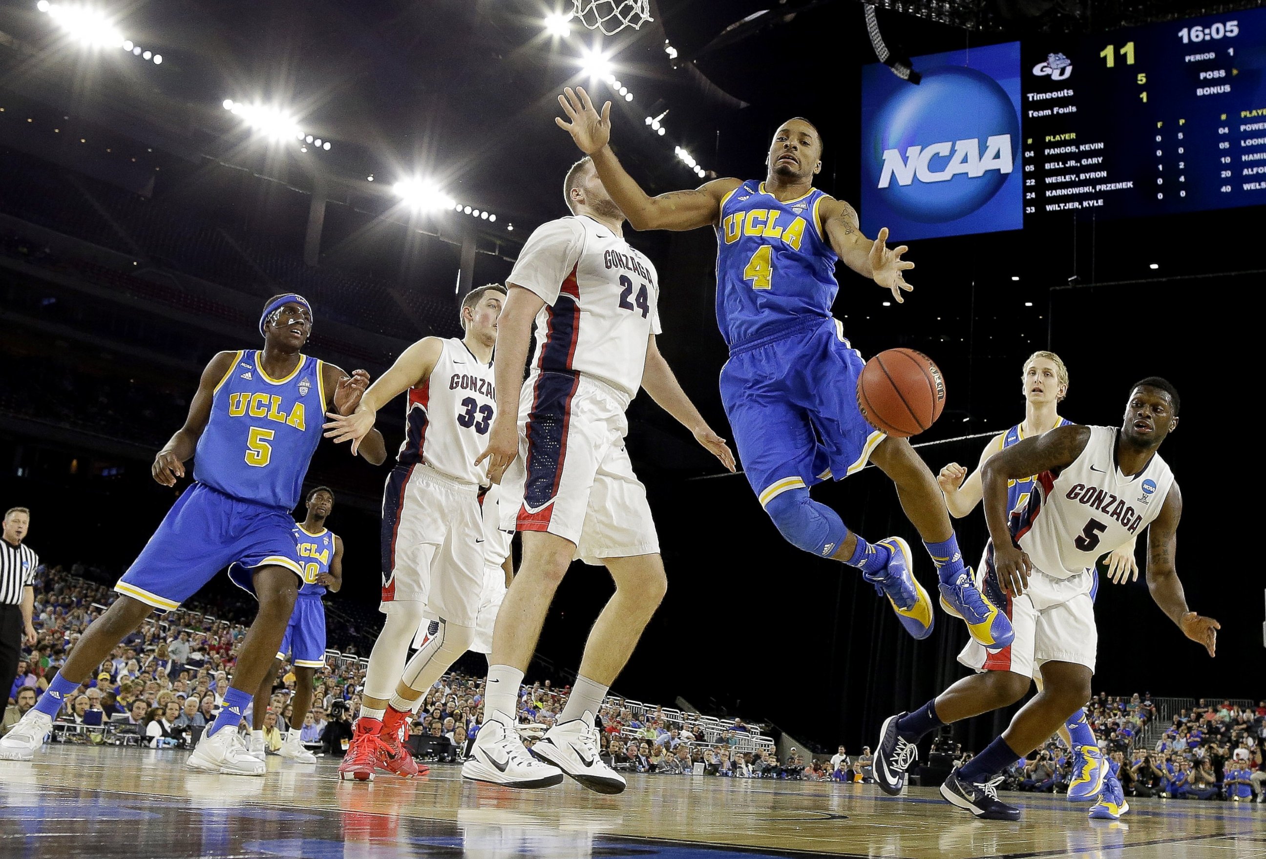PHOTO: UCLA's Norman Powell (4) loses the ball in front of Gonzaga's Przemek Karnowski (24) during the first half of a college basketball regional semifinal game in the NCAA Tournament, March 27, 2015, in Houston.