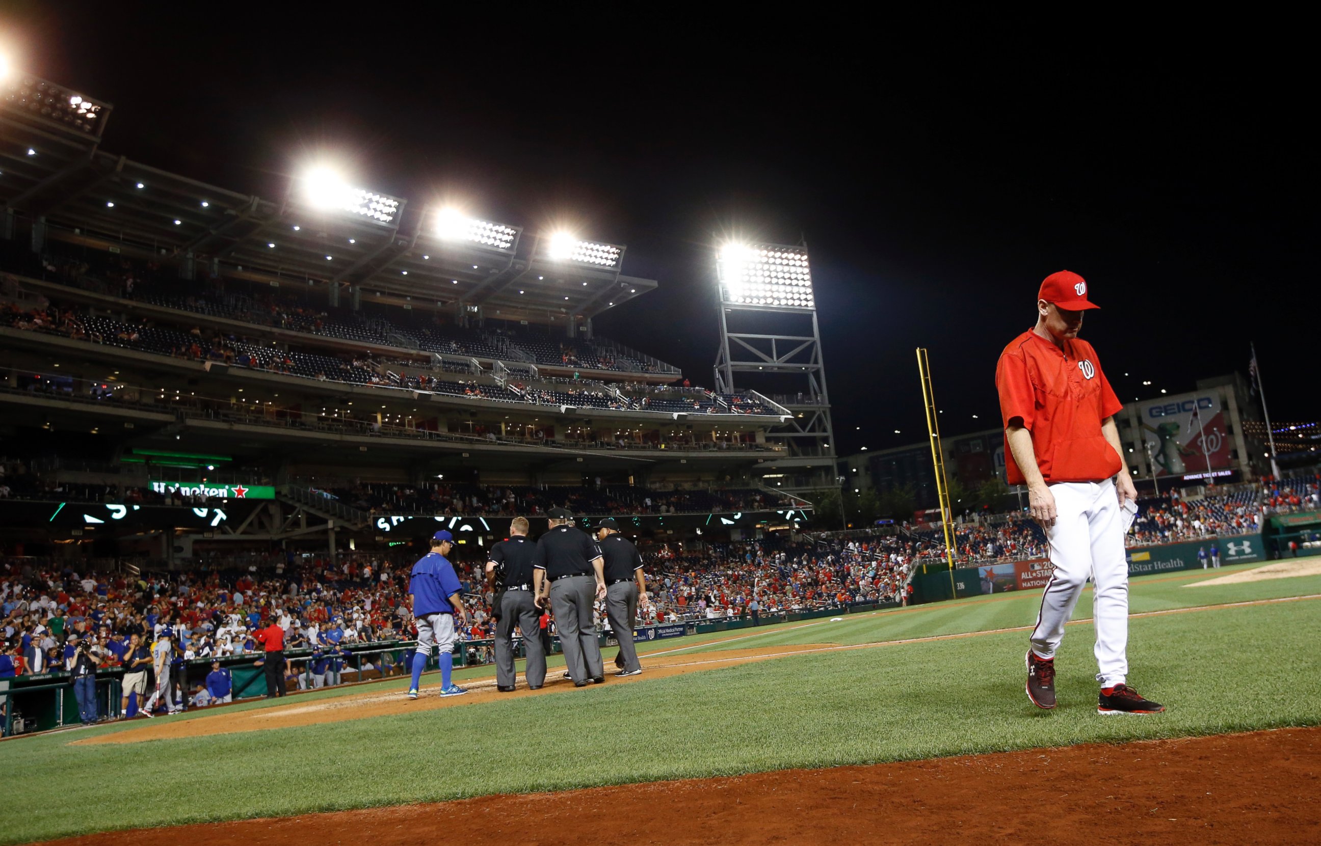 PHOTO: Washington Nationals manager Matt Williams, right, walks away from a meeting with the umpires and Los Angeles Dodgers manager Don Mattingly during the sixth inning in a baseball game at Nationals Park,  July 17, 2015, in Washington. 