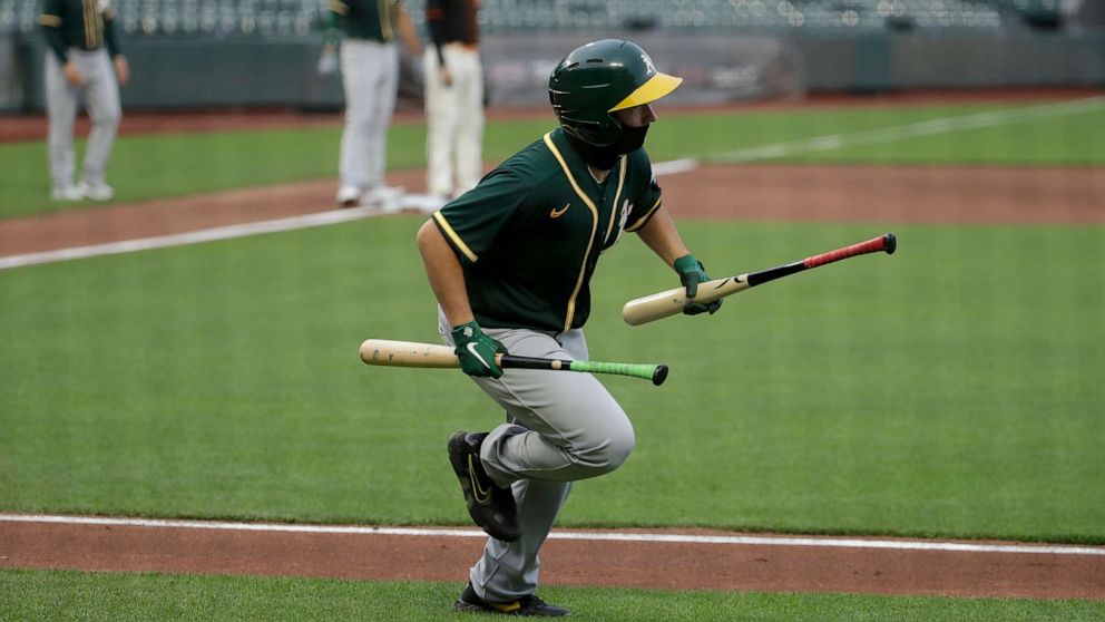 PHOTO: Oakland Athletics ball kid Stewart Thalblum runs with bats during the second inning of an exhibition baseball game between the Athletics and the San Francisco Giants in San Francisco, Tuesday, July 21, 2020.