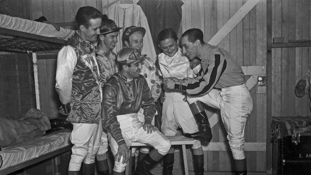 PHOTO: Jockey Eddie Arcaro tells his fellow horse pilots, from left, Buddy Haas, Porter Roberts, Jimmy Stout, Don Meade and Johnny Gilbert, how he guided Warren Wright's Whirlaway to victory in both the Kentucky Derby and The Preakness Stakes.