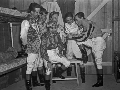 PHOTO: Jockey Eddie Arcaro tells his fellow horse pilots, from left, Buddy Haas, Porter Roberts, Jimmy Stout, Don Meade and Johnny Gilbert, how he guided Warren Wrights Whirlaway to victory in both the Kentucky Derby and The Preakness Stakes.
