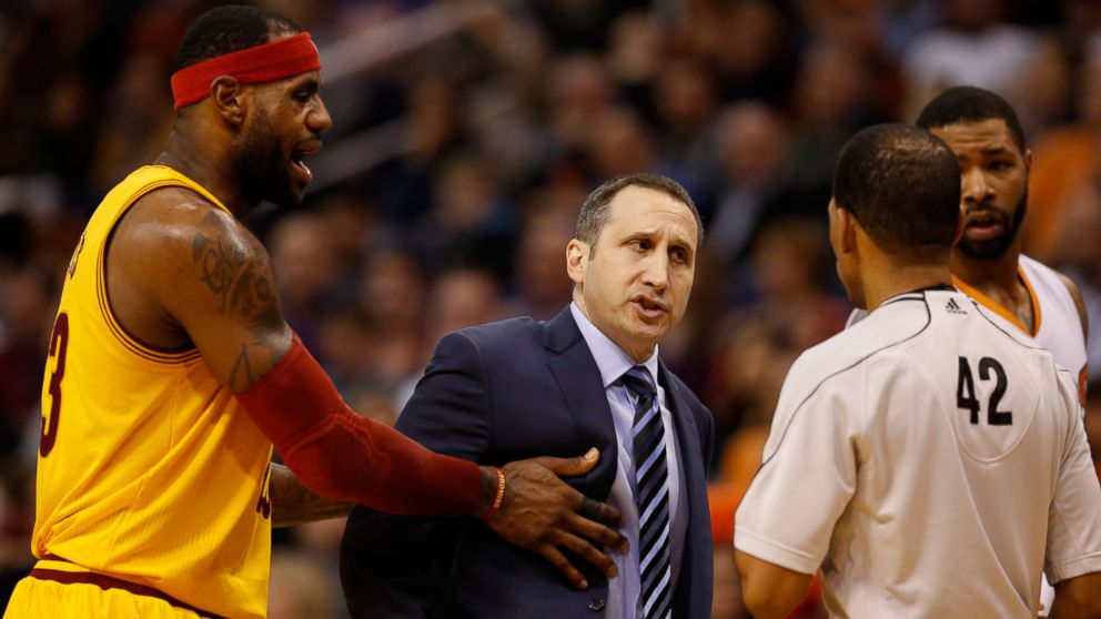 Head coach David Blatt of the Cleveland Cavaliers reacts to referee Eric Lewis as LeBron James holds him back during the an NBA game against the Phoenix Suns at US Airways Center on January 13, 2015 in Phoenix, Arizona.