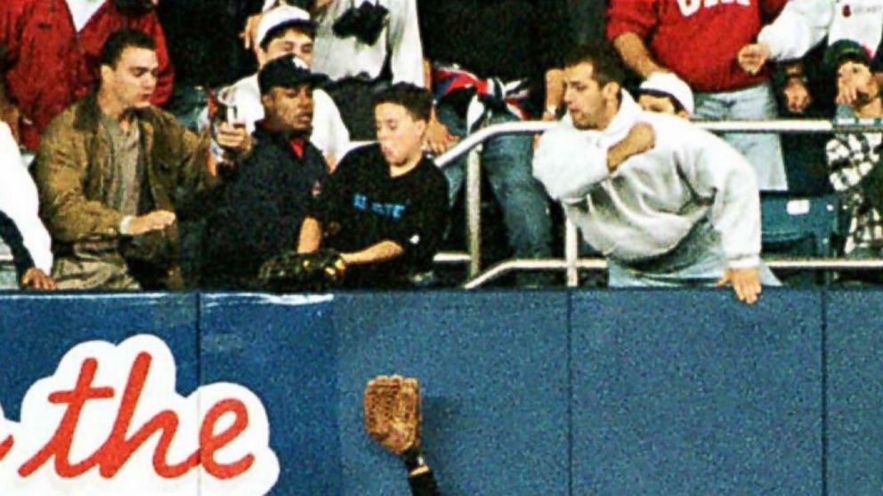 Baltimore Orioles' right fielder Tony Tarasco tries to catch a fly ball hit by the New York Yankees' Derek Jeter, but fan Jeffrey Maier grabs it over the outfield wall, Oct. 9, 1996.