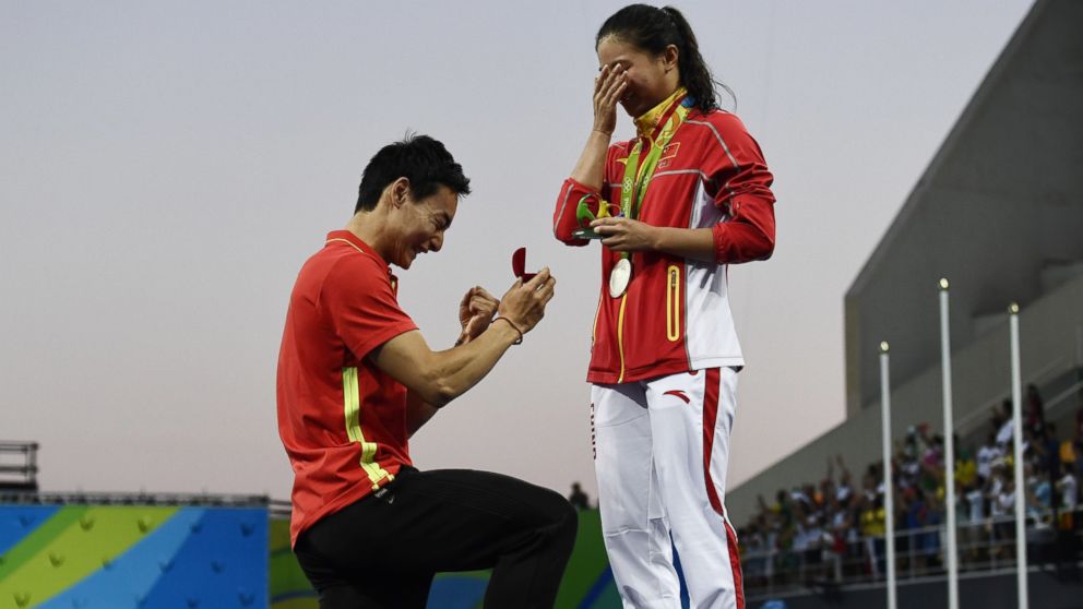 PHOTO: Silver medallist China's He Zi, receives a marriage proposal from Chinese diver Qin Kai during the podium ceremony of the Women's diving 3m Springboard Final at the Rio 2016 Olympic Games in Rio de Janeiro, Brazil, Aug. 14, 2016.