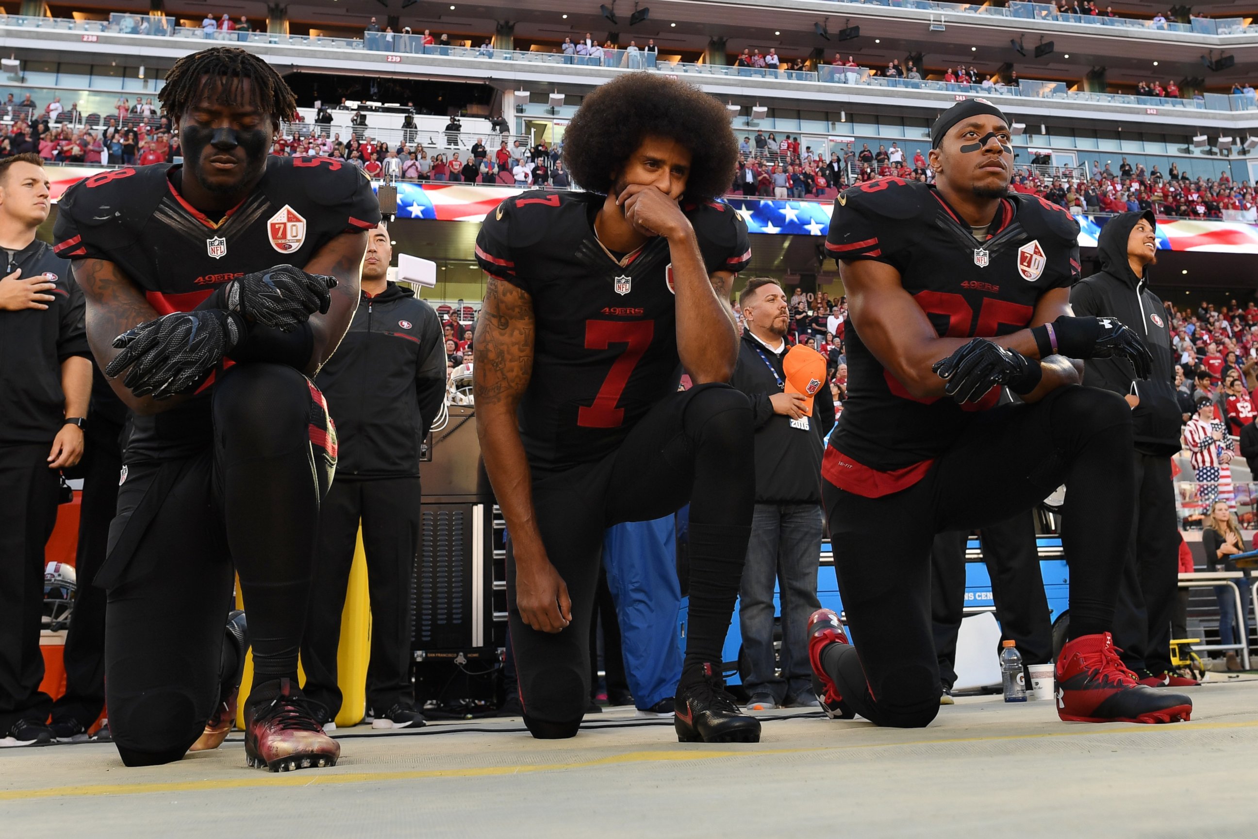 PHOTO: From left, Eli Harold, #58, Colin Kaepernick, #7, and Eric Reid, #35, of the San Francisco 49ers kneel in protest during the national anthem prior to their NFL game against the Arizona Cardinals, Oct. 6, 2016, in Santa Clara, California.
