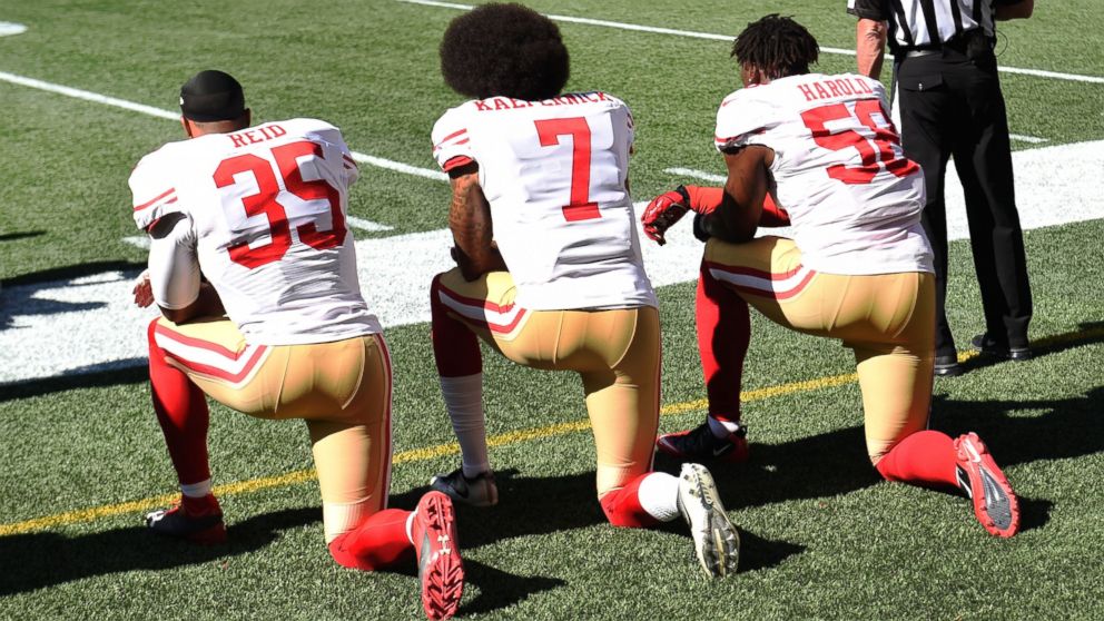 PHOTO: Eric Reid, #35, Colin Kaepernick, #7,  and Eli Harold, #58, of the San Francisco 49ers kneel on the sidelines during the national anthem before the game against the Seattle Seahawks, Sept. 25, 2016, in Seattle. 