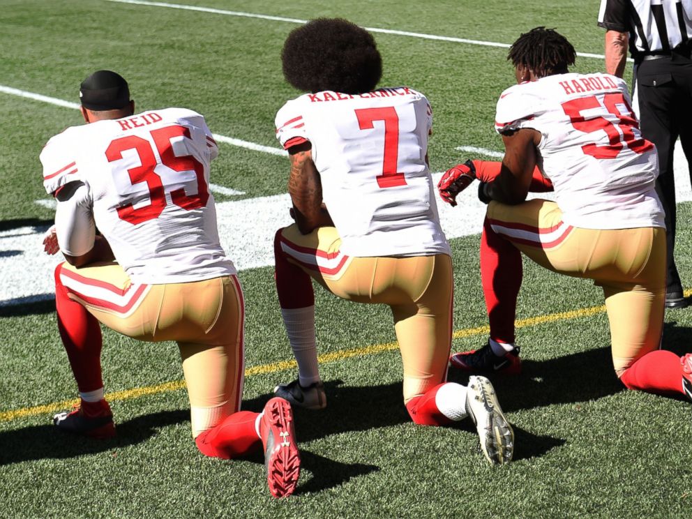 PHOTO: Eric Reid, #35, Colin Kaepernick, #7, and Eli Harold, #58, of the San Francisco 49ers kneel on the sidelines during the national anthem before the game against the Seattle Seahawks, Sept. 25, 2016, in Seattle.