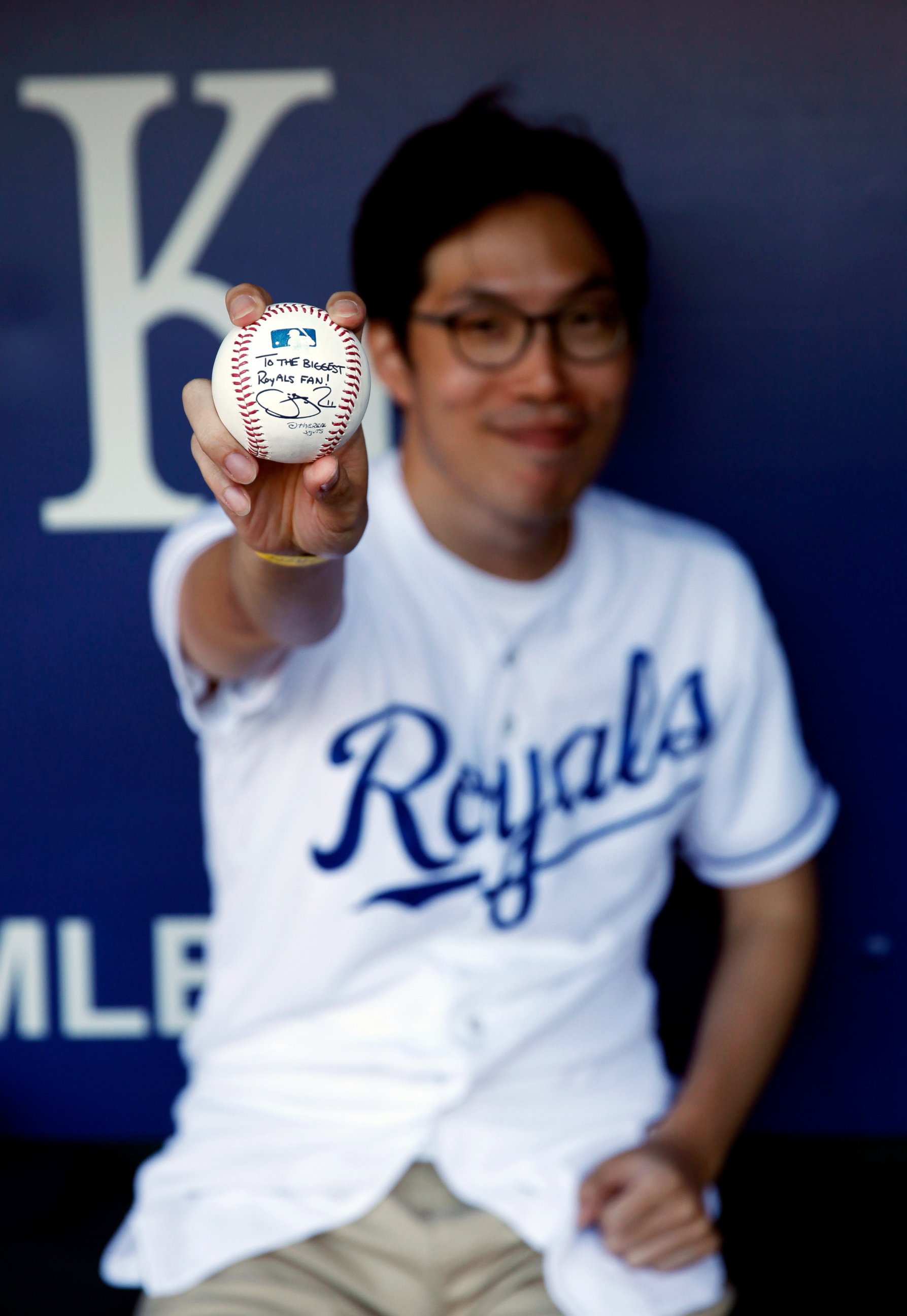 PHOTO: Kansas City Royals fan Sungwoo Lee of Korea shows of a signed baseball prior to the game against the Oakland Athletics at Kauffman Stadium, Aug. 11, 2014 in Kansas City, Mo.