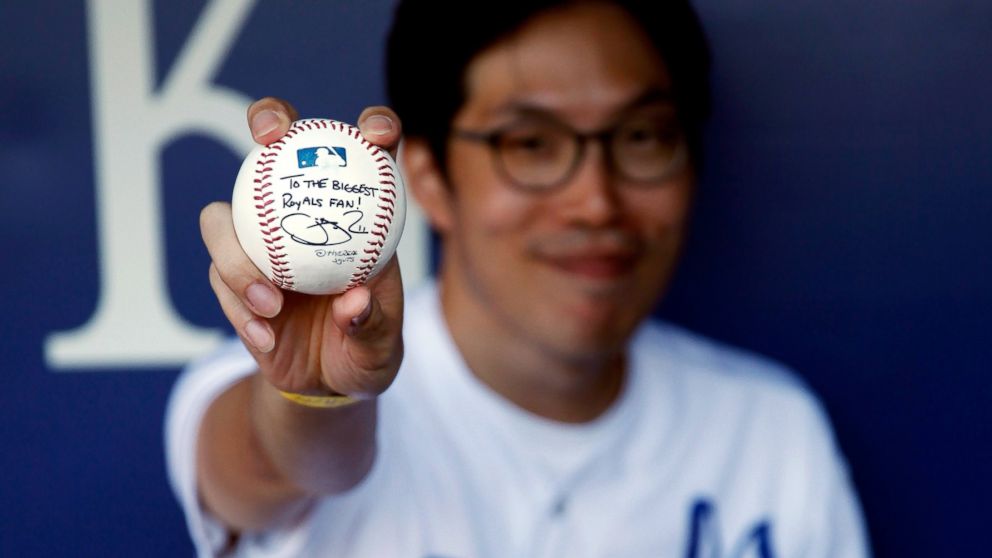 PHOTO: Kansas City Royals fan Sungwoo Lee of Korea shows of a signed baseball prior to the game against the Oakland Athletics at Kauffman Stadium, Aug. 11, 2014 in Kansas City, Mo.