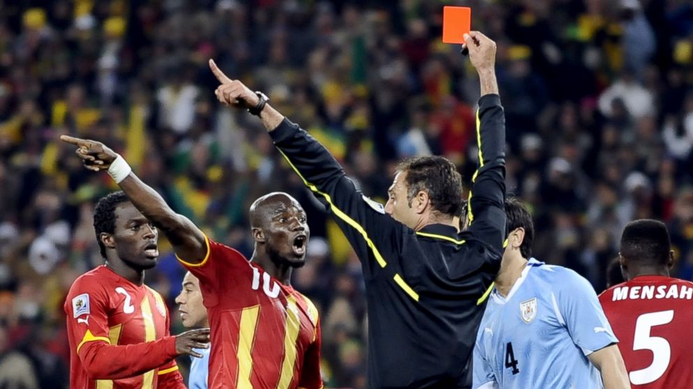 PHOTO: Portuguese referee Olegario Benquerenca hands a red card to Uruguay's striker Luis Suarez (unseen) during the 2010 World Cup quarter-final football match Uruguay vs. Ghana, July 2, 2010, in Johannesburg. 