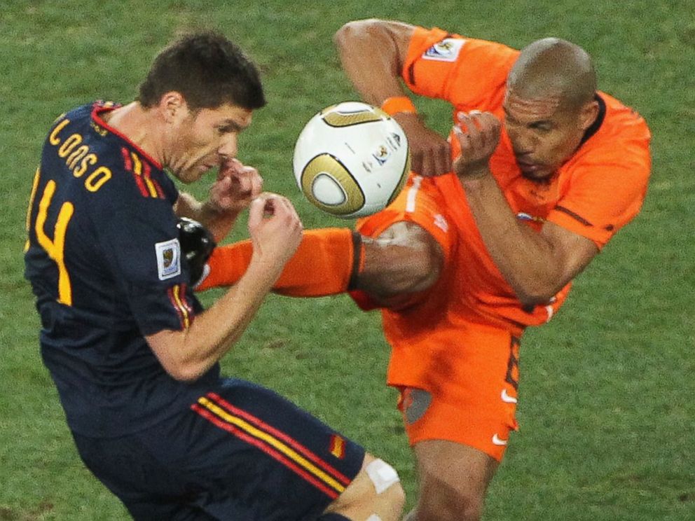 PHOTO: Nigel de Jong, right, of the Netherlands tackles Xabi Alonso, center, of Spain with a kick in the chest during the 2010 World Cup on July 11, 2010 in Johannesburg, South Africa. 