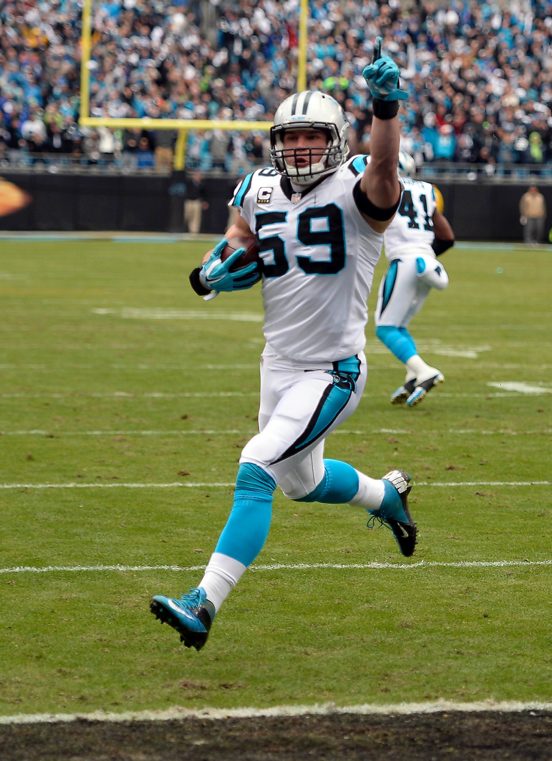 PHOTO: Luke Kuechly celebrates as he returns an interception for a touchdown during the first quarter on Jan. 17, 2016, at Bank of America Stadium in Charlotte, N.C. 