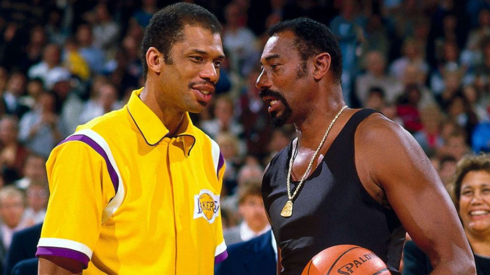 PICTURED: LA Lakers' Kareem Abdul Jabbar talks to Wilt Chamberlain on the court before playing an NBA game against the Kansas City Kings on April 6, 1984 at The Forum in Inglewood, California.