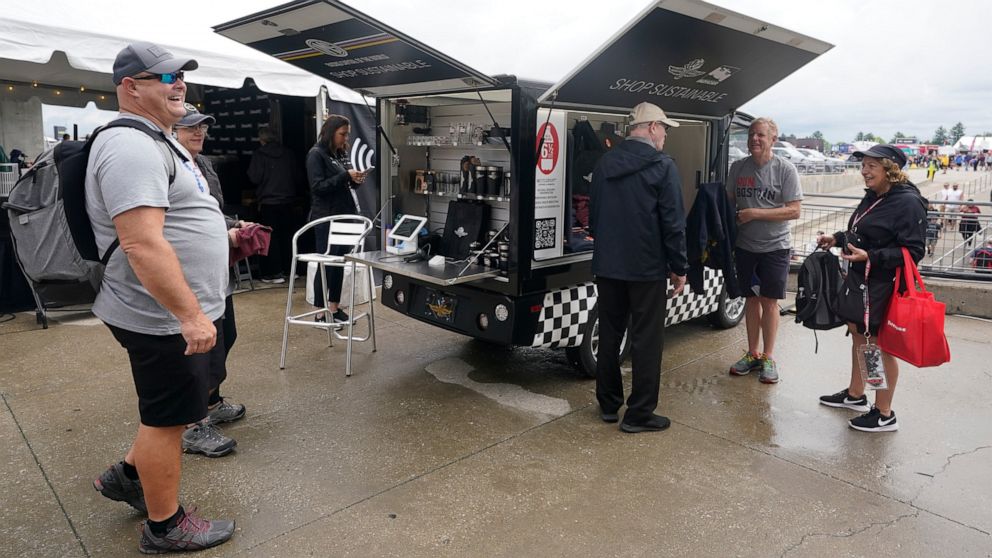 Race fans look at shirts that are made from plastic bottles during the final practice for the Indianapolis 500 auto race at Indianapolis Motor Speedway, Friday, May 27, 2022, in Indianapolis. (AP Photo/Darron Cummings)