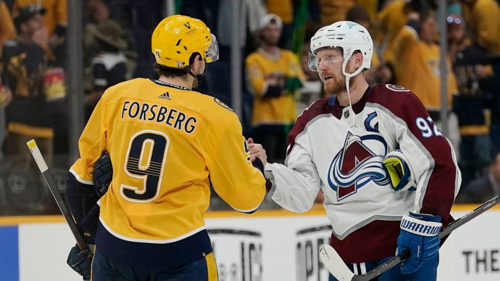 Colorado Avalanche left wing Gabriel Landeskog (92) shakes hands with Nashville Predators' Filip Forsberg (9) after Game 4 of an NHL hockey first-round playoff series Monday, May 9, 2022, in Nashville, Tenn. The Avalanche won 5-3 to sweep the series 