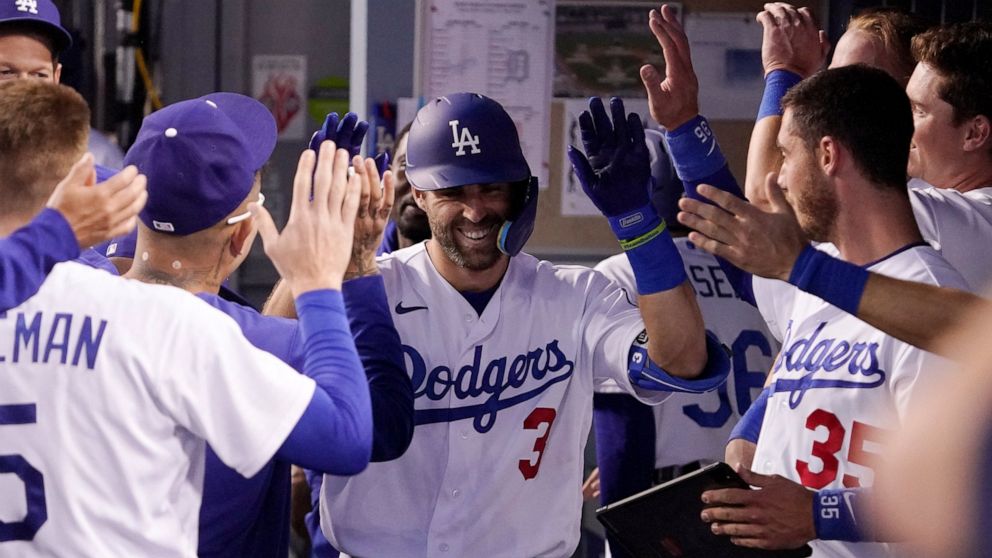 Los Angeles Dodgers' Chris Taylor is congratulated by teammates in the dugout after hitting a solo home run during the second inning of a baseball game against the Detroit Tigers Friday, April 29, 2022, in Los Angeles. (AP Photo/Mark J. Terrill)