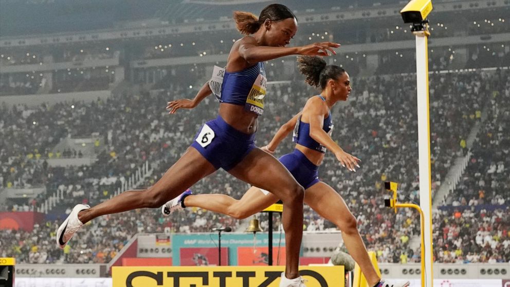 Dalilah Muhammad, left, of the United States, finishes ahead of Sydney Mclaughlin, right, of the United States, to win the the women's 400 meter hurdles final and set a new world record at the World Athletics Championships in Doha, Qatar, Friday, Oct