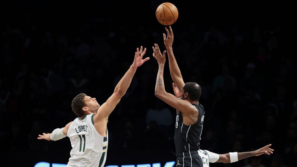 Brooklyn Nets forward Kevin Durant (7) shoots against Milwaukee Bucks center Brook Lopez (11) during the first half of an NBA basketball game, Friday, Dec. 23, 2022, in New York. (AP Photo/Jessie Alcheh)