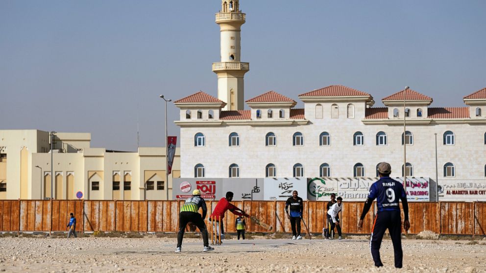 People play cricket in the streets in Doha, Qatar, Friday, Nov. 25, 2022. As dawn broke Friday as Qatar hosts the World Cup, the laborers who built this energy-rich country's stadiums, roads and rail filled empty stretches of asphalt and sandlots to 