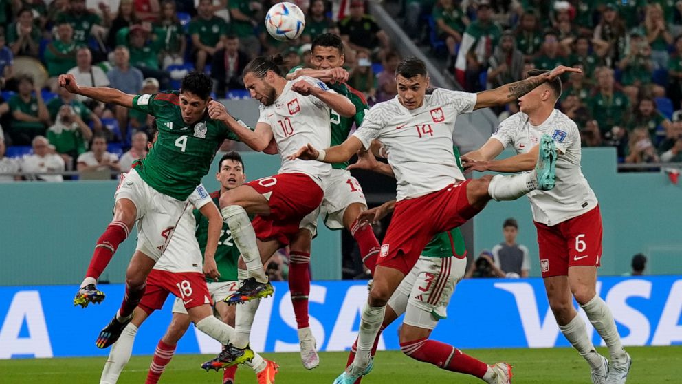 Poland's Grzegorz Krychowiak (10) and Mexico's Edson Alvarez go for a header during a World Cup group C soccer match at the Stadium 974 in Doha, Qatar, Tuesday, Nov. 22, 2022. (AP Photo/Martin Meissner)