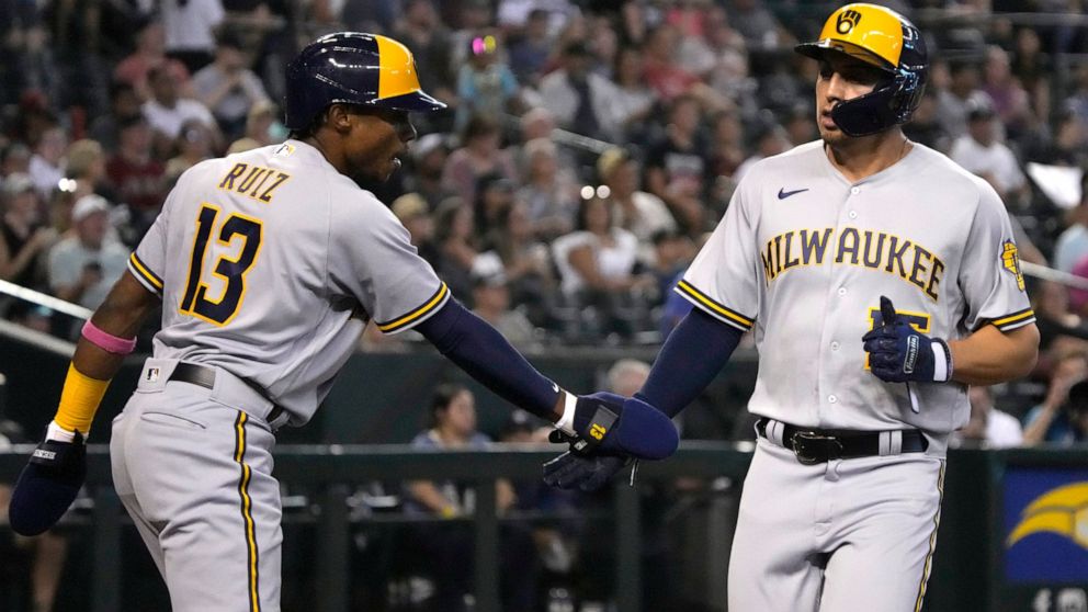Milwaukee Brewers' Tyrone Taylor celebrates with Esteury Ruiz (13) after scoring a run against the Arizona Diamondbacks on a ball hit by Victor Caratini in the second inning during a baseball game, Saturday, Sept. 3, 2022, in Phoenix. (AP Photo/Rick 