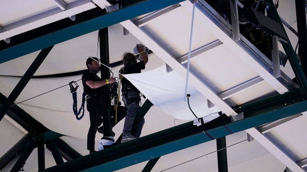 American Airlines Center workers set up a barrier to help prevent rain from falling onto the basketball court during the second half of Game 4 of the NBA basketball playoffs Western Conference finals between the Dallas Mavericks and the Golden State 
