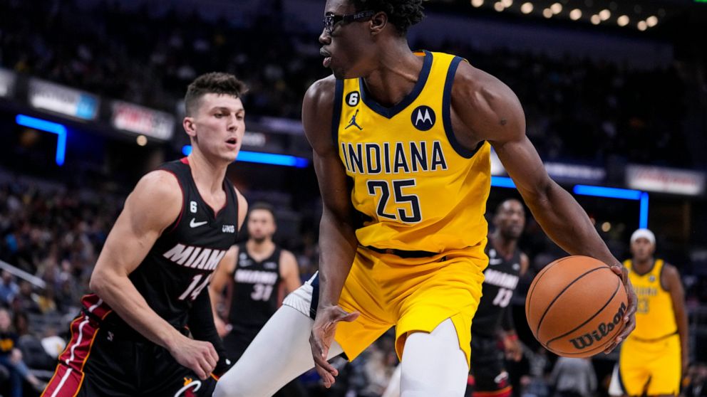 Indiana Pacers forward Jalen Smith (25) drives on Miami Heat guard Tyler Herro (14) during the second half of an NBA basketball game in Indianapolis, Friday, Nov. 4, 2022. The Pacers defeated the Heat 101-99. (AP Photo/Michael Conroy)