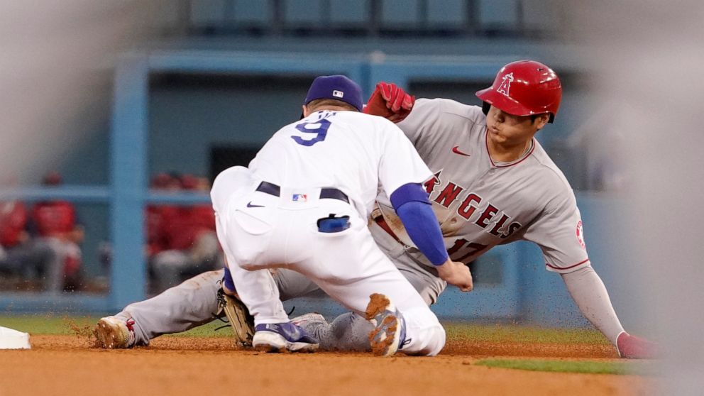 Los Angeles Angels' Shohei Ohtani, right, is tagged out at second by Los Angeles Dodgers second baseman Gavin Lux as he tries to steal during the fourth inning of a baseball game Tuesday, June 14, 2022, in Los Angeles. (AP Photo/Mark J. Terrill)