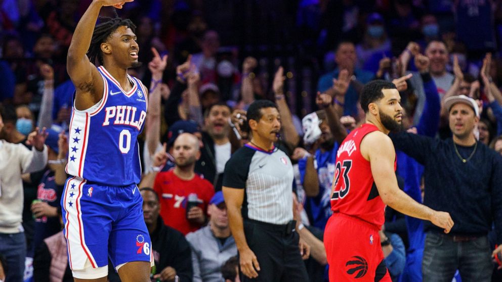 Philadelphia 76ers' Tyrese Maxey, left, reacts to his three-pointer as Toronto Raptors' Fred VanVleet, right, looks on during the first half of Game 1 of an NBA basketball first-round playoff series, Saturday, April 16, 2022, in Philadelphia. (AP Pho