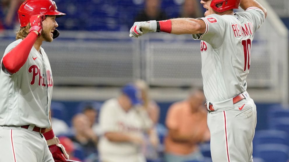 Philadelphia Phillies' J.T. Realmuto (10) celebrates with Alec Bohm after scoring on a solo home run during the sixth inning of a baseball game against the Miami Marlins, Wednesday, Sept. 14, 2022, in Miami. (AP Photo/Lynne Sladky)