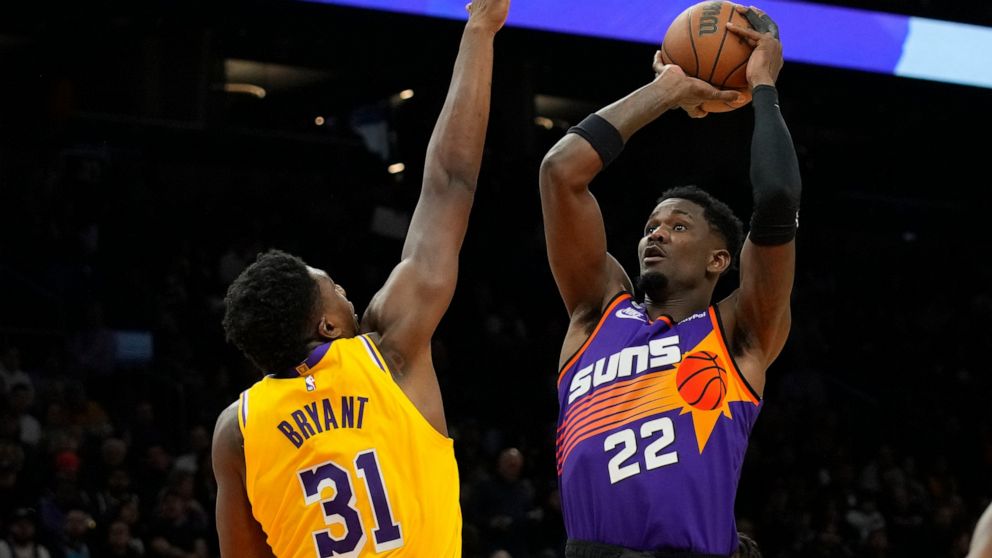 Phoenix Suns center Deandre Ayton shoots over Los Angeles Lakers center Thomas Bryant (31) during the second half of an NBA basketball game, Monday, Dec. 19, 2022, in Phoenix. (AP Photo/Rick Scuteri)
