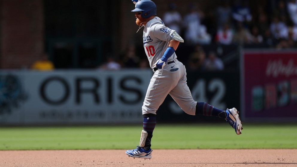 Los Angeles Dodgers' Justin Turner pumps his fist as he runs the bases after hitting a grand slam off San Diego Padres' Craig Stammen in the seventh inning of a baseball game Sunday, Sept. 11, 2022, in San Diego. (AP Photo/Derrick Tuskan)