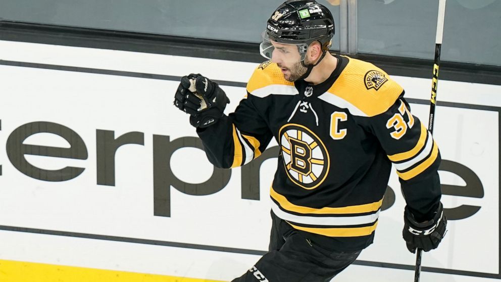 Boston Bruins' Patrice Bergeron (37) celebrates after scoring in the first period of Game 4 of an NHL hockey Stanley Cup first-round playoff series against the Carolina Hurricanes, Sunday, May 8, 2022, in Boston. (AP Photo/Steven Senne)