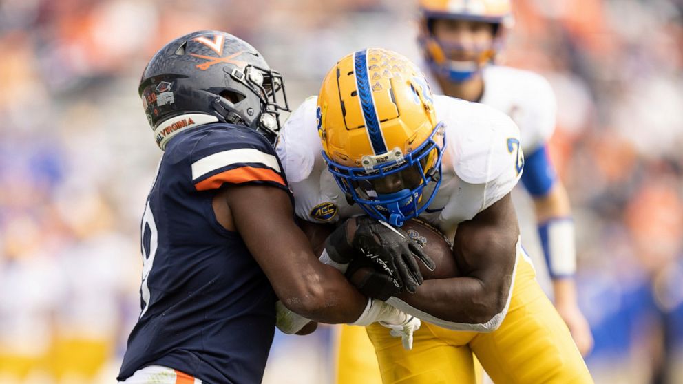 Pittsburgh's Israel Abanikanda (2) fights to keep the ball against Virginia during the first half of an NCAA college football game in Charlottesville, Va., Saturday, Nov.. 12, 2022. (AP Photo/Mike Kropf)
