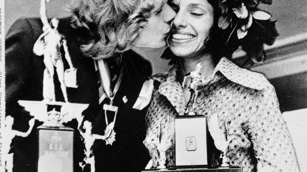 FILE - Olavi Suomalainen of Finland, winner of the men's division of the Boston A.A. Marathon April 17, 1972, kisses Nina Kuscsik of Long Island, N.Y., winner of the women's division, at the trophy presentation April 18, 1972. As the 2022 Boston Mara