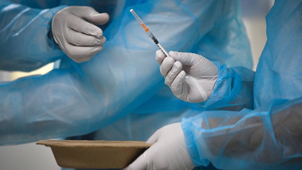 Medical staff handle a syringe as Romania starts administering the third dose booster Pfizer vaccine at the Matei Bals hospital in Bucharest, Romania, Tuesday, Sept. 28, 2021. Romania reported 11049 new COVID-19 infections in the past 24 hour interva