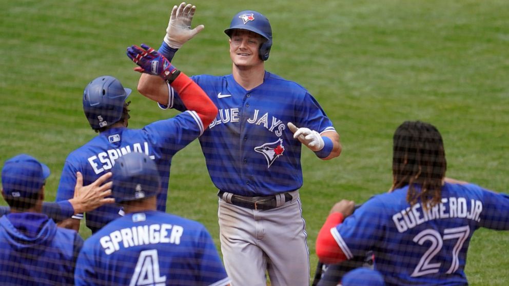 Toronto Blue Jays' Matt Chapman, top, is congratulated by teammates after hitting a home run against the Oakland Athletics during the seventh inning of a baseball game in Oakland, Calif., Wednesday, July 6, 2022. (AP Photo/Jeff Chiu)