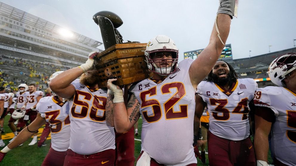 Iowa State offensive lineman Trevor Downing (52) celebrates with the Cy-Hawk trophy after an NCAA college football game against Iowa, Saturday, Sept. 10, 2022, in Iowa City, Iowa. Iowa State won 10-7. (AP Photo/Charlie Neibergall)