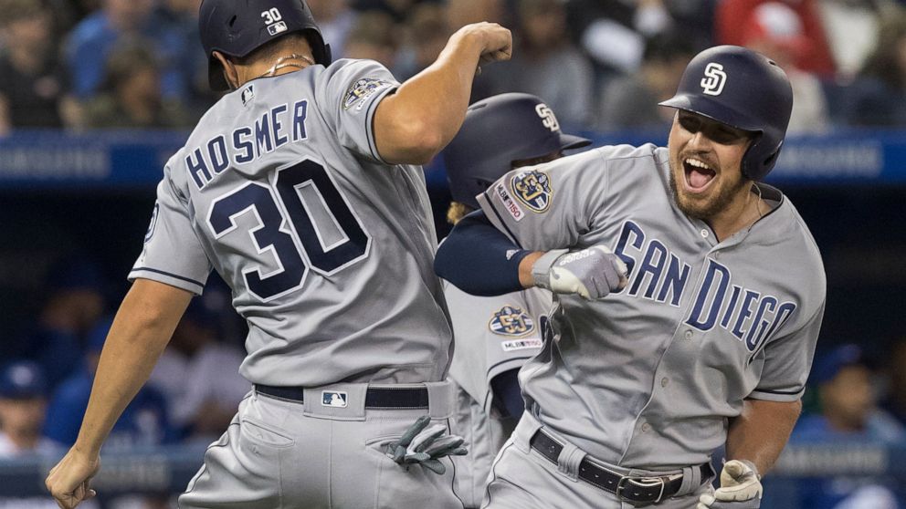 San Diego Padres' Hunter Renfroe celebrates with Eric Hosmer after Renfroe hit a three-run home run against the Toronto Blue Jays during the eighth inning of a baseball game Friday, May 24, 2019, in Toronto. (Fred Thornhill/The Canadian Press via AP)